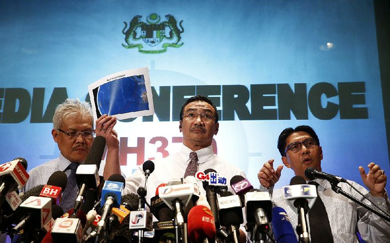 Malaysian acting Transport Minister Hishamuddin Hussein, center, shows maps of South Corridor and North Corridor of the search and rescue as director general of the Malaysian Department of Civil Aviation, Azharuddin Abdul Rahman, right, and Malaysian Deputy Foreign Minister Hamzah Zainudin during a press conference at a hotel next to the Kuala Lumpur International Airport, in Sepang, Malaysia, Monday, March 17, 2014. The search for the missing Malaysian jet pushed deep into the northern and southern hemispheres Monday as Australia took the lead in scouring the seas of the southern Indian Ocean and Kazakhstan - about 10,000 miles to the northwest - answered Malaysia's call for help in the unprecedented hunt. (AP Photo/Vincent Thian)