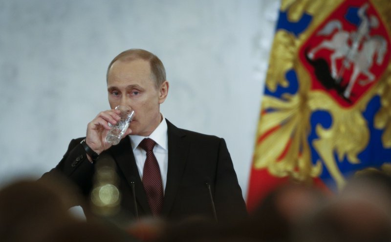 Russian President Vladimir Putin drinks water as he addresses the Federal Assembly in the Kremlin in Moscow, Tuesday, March 18, 2014. With a sweep of his pen, President Vladimir Putin added Crimea to the map of Russia on Tuesday, describing the move as correcting past injustice and a response to what he called Western encroachment upon Russia's vital interests. 