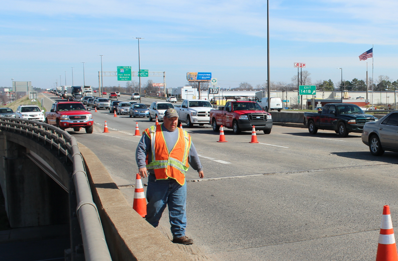 An Arkansas State Highway and Transportation Department worker arranges cones Tuesday during maintenance work on and near the Interstate 30 river bridge.