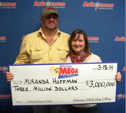 Miranda Huffman and her husband, Jeff, pose with an oversized check in this photo released by the Arkansas Scholarship Lottery.