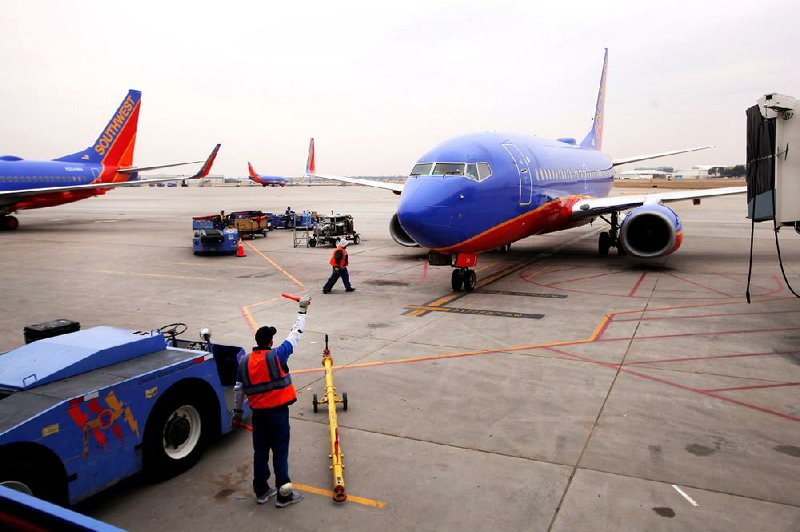 An employee guides a Southwest Airlines jet to a gate at Dallas Love Field in early February. Onethird of all flights arrived late in January, according to a U.S. Department of Transportation report released Tuesday. 
