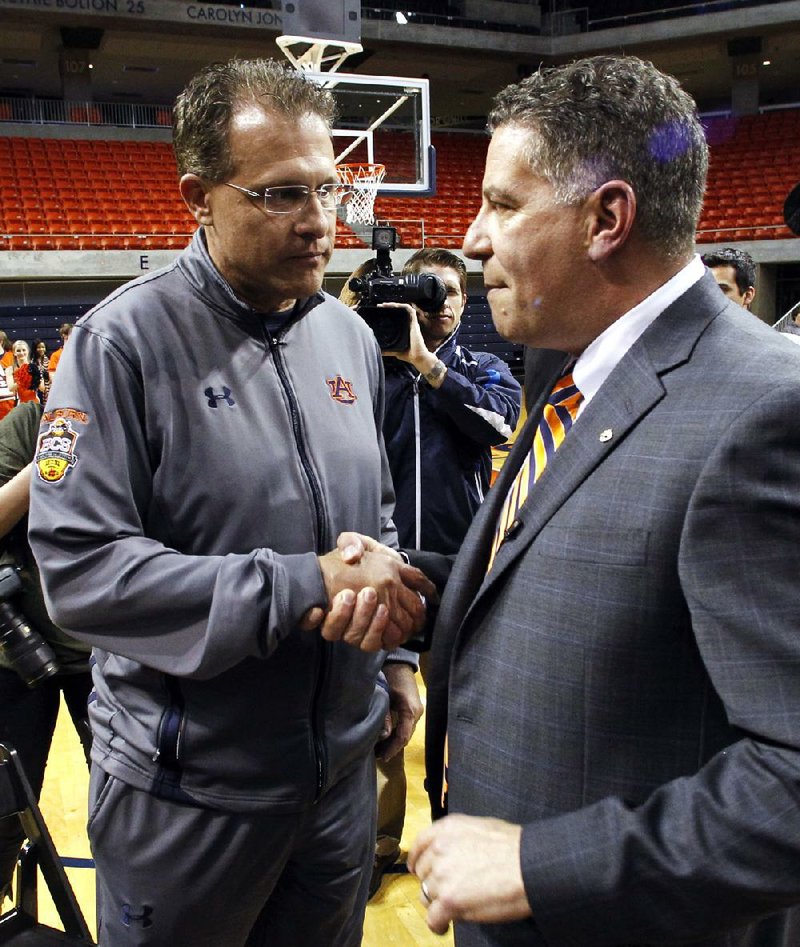 Gus Malzahn, Auburn’s football coach, greets Bruce Pearl (right) on Tuesday after Pearl was hired as the Tigers’ men’s basketball coach in Auburn, Ala. 