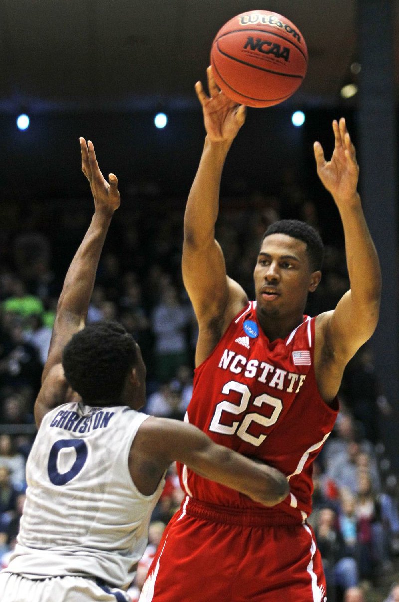 N.C. State guard Ralston Turner (22) throws a pass over Xavier guard Semaj Christon during the fi rst half of the Wolfpack’s 74-59 victory over the Musketeers on Tuesday in Dayton, Ohio. 