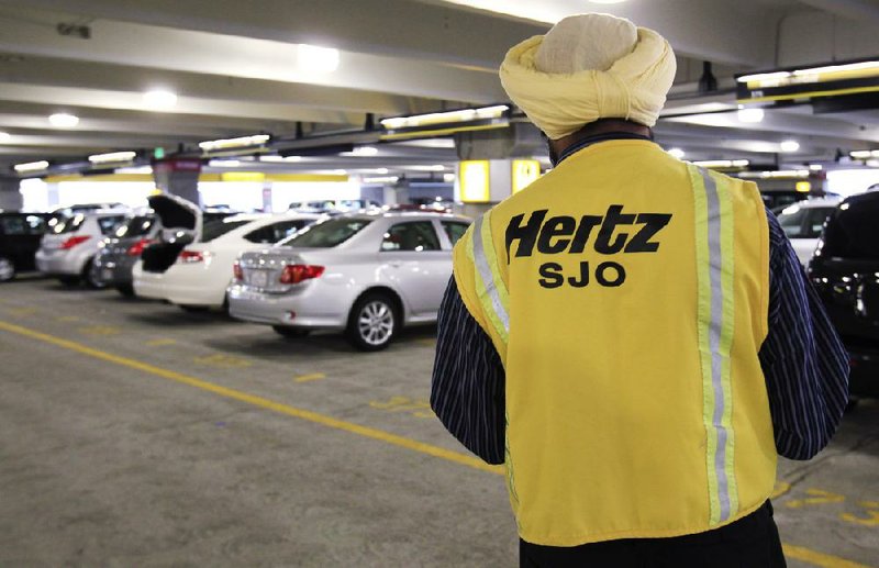 A Hertz rental car worker checks out cars at San Jose International Airport in San Jose, Calif., in this file photo. Hertz announced Tuesday that it plans to spin off its equipment rental business into a separate publicly traded company. 