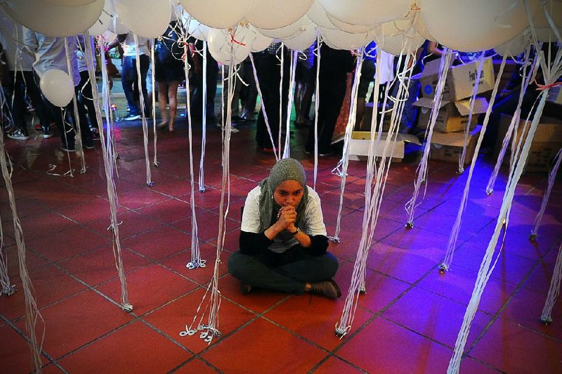 A Malaysian Muslim woman pauses Tuesday during an event for the missing Malaysia Airlines Flight 370 at a shopping mall in Petaling Jaya, on the outskirt of Kuala Lumpur, Malaysia. 