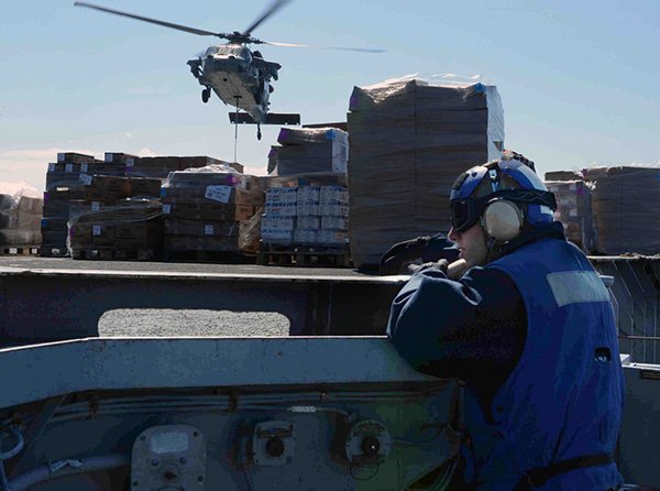 U.S. NAVY PHOTO BY MASS COMMUNICATION SPECIALIST 3RD CLASS RYAN SEELBACH 
Aviation Boatswain’s Mate (Handling) Airman Adam Brown, from Rogers, stands watch as a phone talker during a vertical replenishment aboard the aircraft carrier USS George H.W. Bush (CVN 77). George H.W. Bush is on a scheduled deployment supporting maritime security operations and theater security cooperation efforts in the U.S. 6th Fleet area of operations.