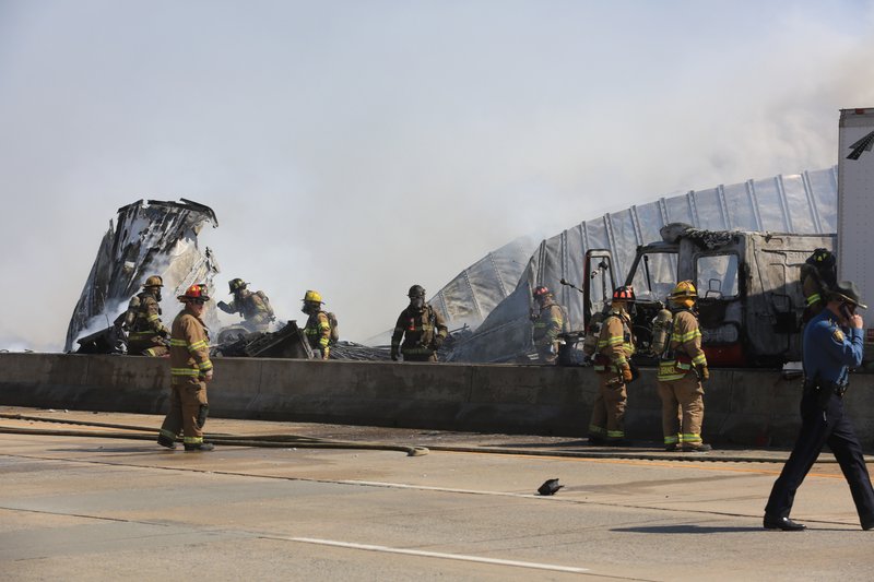 Little Rock firefighters and state police work the scene of an accident Wednesday afternoon involving two 18-wheelers that both caught fire on Interstate 440 eastbound just before the bridge over the Arkansas River in Little Rock.