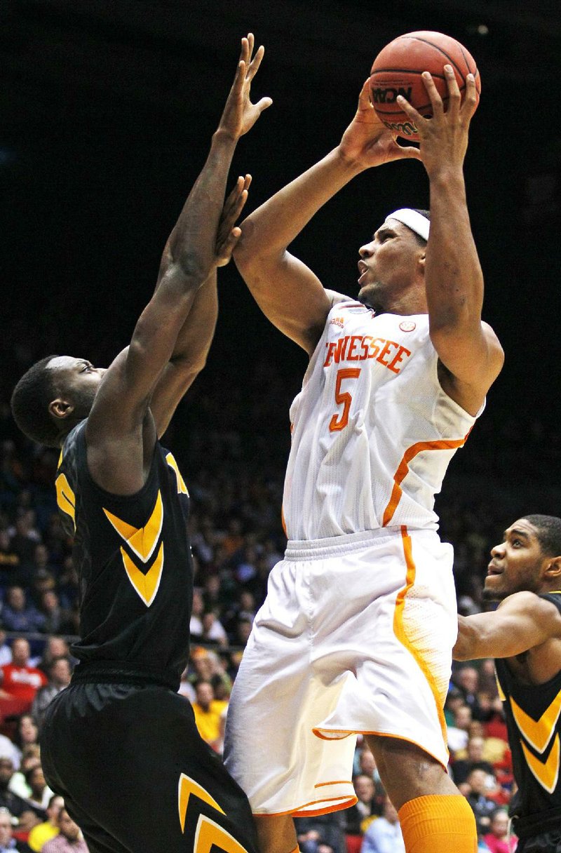 Tennessee forward Jarnell Stokes (5) shoots over Iowa center Gabriel Olaseni on Wednesday in the second half of the Volunteers’ 78-65 overtime victory in the NCAA Tournament in Dayton, Ohio. Stokes scored 18 points and grabbed 13 rebounds in the victory. 