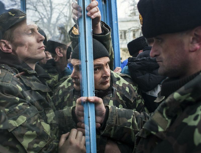 Ukrainian soldiers struggle to defend the entrance to navy headquarters from Crimean self-defense forces storming the base Wednesday in Sevastopol as Russia seized military installations across the region. 