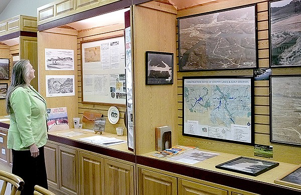 STAFF PHOTO LYNN ATKINS 
Volunteer Melissa Kendus looks at an exhibit in one of the new cabinets in the Cooper Room at the Bella Vista Museum. The museum has reopened for the year with a new look and new exhibits.