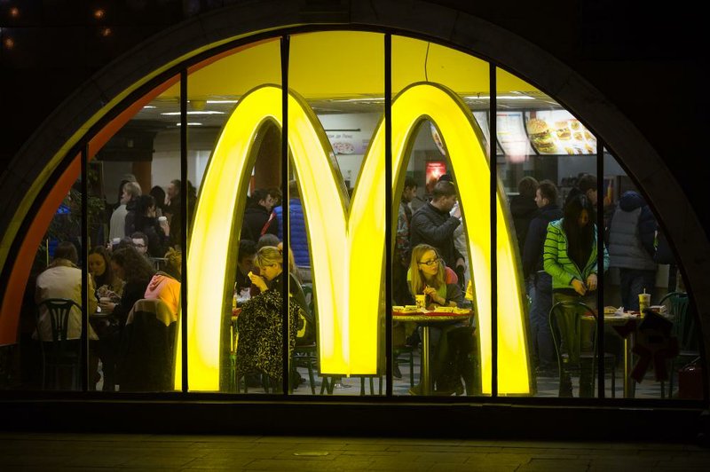 Bloomberg Photo Service 'Best of the Week': Customers dine behind an illuminated "M" logo at a McDonald's Corp. fast food restaurant in Moscow, Russia, on Sunday, March 16, 2014. The U.S. and the European Union warned Russia not to annex Crimea after a referendum in the southern Ukrainian region, setting the stage for sanctions on Russia in the worst diplomatic standoff since the Cold War. Photographer: Andrey Rudakov/Bloomberg