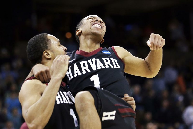 Harvard’s Siyani Chambers (right) celebrates with teammate Brandyn Curry after the Crimson beat Cincinnati 61-57 in the second round of the NCAA Tournament on Thursday in Spokane, Wash. 