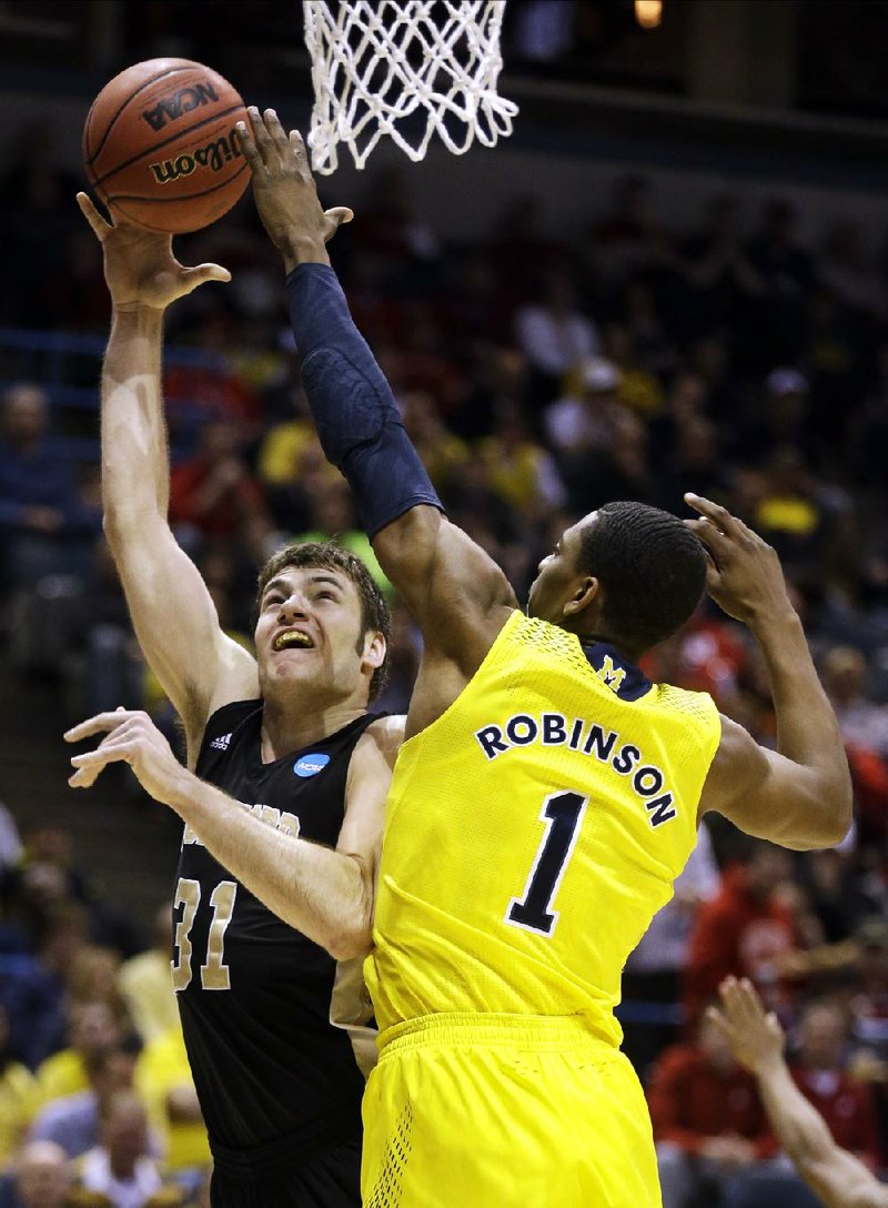Michigan forward Glenn Robinson III (1) tries to block a shot by Wofford forward C.J. Neumann during Thursday’s NCAA Tournament game in Milwaukee. Robinson finished with 14 points. 
