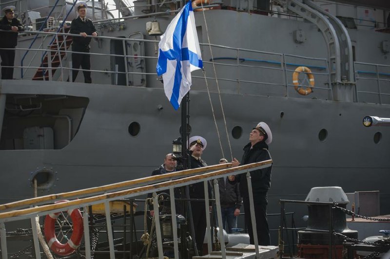 Sailors raise a Russian navy flag aboard the Ukrainian naval vessel Lutsk after it was surrounded and seized by Russian forces Thursday in the Crimean port of Sevastopol. 