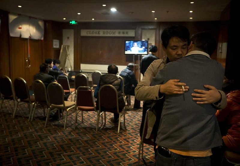 Relatives of Chinese passengers aboard the missing Malaysia Airlines, MH370 comfort each other as they wait for a news briefing by the airlines' officials at a hotel ballroom in Beijing, China, Thursday, March 20, 2014. Flight 370 disappeared March 8 on a night flight from Kuala Lumpur to Beijing. Malaysian authorities have not ruled out any possible explanation, but have said the evidence so far suggests the flight was deliberately turned back across Malaysia to the Strait of Malacca, with its communications systems disabled. They are unsure what happened next. (AP Photo/Andy Wong)
