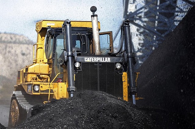 A Caterpillar earth mover moves piles of coal at the Wildcat Coal Load-Out Terminal, owned by Intermountain Power Agency, outside Price, Utah, U.S., on Wednesday, March 5, 2014. The facility receives coal via trucks from the local mines and transfers it to railcars for transport to power generation facilities. Photographer: George Frey/Bloomberg