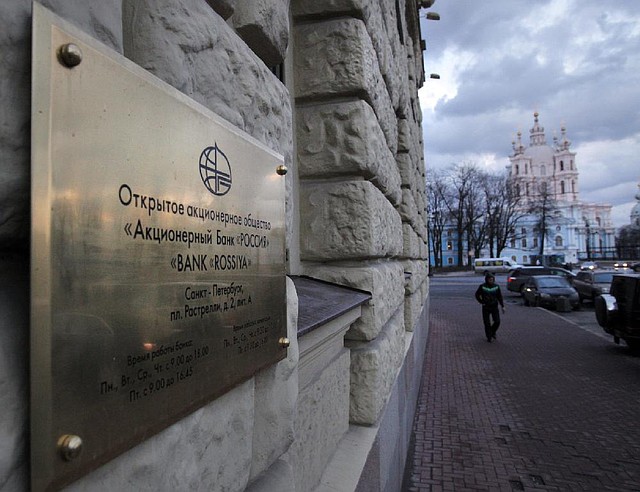 A person walks outside the head office of Bank Rossiya in St. Petersburg, Russia, Friday, March 21, 2014. Two Russian banks, including Bank Rossiya, the Russian lender which was put on the Treasury's sanctions list, said Visa and MasterCard have stopped providing services to them. Bank Rossiya is a private bank owned by Yuri Kovalchuk, considered to be Russian President Vladimir Putin's longtime friend and banker. With about $10 billion in assets, Rossiya ranks as the 17th-largest bank in Russia and maintains numerous ties to banks in the United States, Europe and elsewhere. (AP Photo/Elena Ignatyeva)