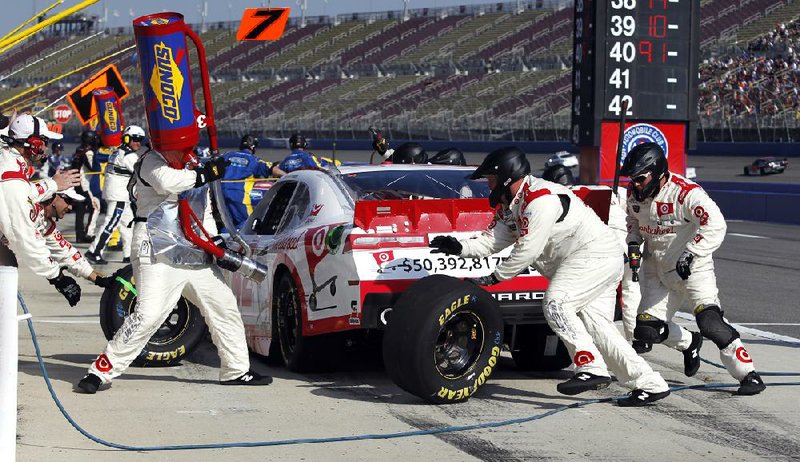 Crew members for Kyle Larson perform a pit stop during Saturday’s NASCAR Nationwide race at Auto Club Speedway in Fontana, Calif. Larson held off Kevin Harvick and Kyle Busch to earn his first career Nationwide victory. Complete results, Page 13C 