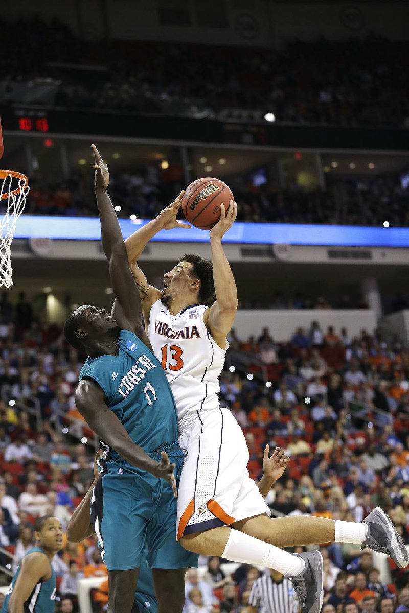 Virginia forward Anthony Gill (13) shoots over Coastal Carolina center El Hadji Ndieguene (11) during Friday’s 70-59 Cavaliers victory in Raleigh, N.C. Gill and his fellow off-the-bench players have accounted for 37.2 percent of the team’s scoring this season. 