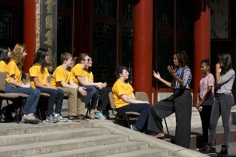 U.S. first lady Michelle Obama, third from right, greets a group of American schoolchildren who are visiting China during their spring break, before they watch a Peking opera performance at the Summer Palace in Beijing, Saturday, March 22, 2014. (AP Photo/Alexander F. Yuan)