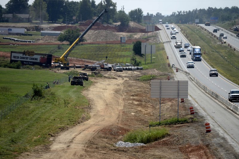FILE PHOTO &#8212; A billboard is removed last September to make way for construction on an interchange at Interstate 540 and Don Tyson Parkway. Arkansas Highway and Transportation Department officials said Northwest Arkansas can expect to see more than $400 million in highway construction in the next seven years.