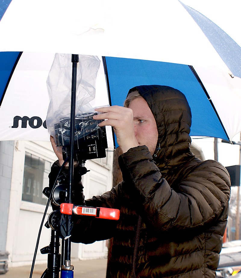 Staff Photo Dodie Evans Zak Heald, award-winning Gravette graduate, removes a protective cover from a camera during a recent film shoot in Gravette. Heald, whose home is Bella Vista, is a student at John Brown University. He has won best student cinematographer honors in a Little Rock competition.