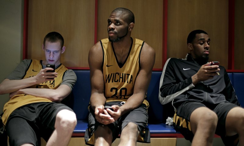Wichita State’s Zach Bush (from left), Kadeem Coleby and Darius Carter relax in the locker room after practice Saturday in St. Louis. Wichita State plays Kentucky in a third-round game today. 