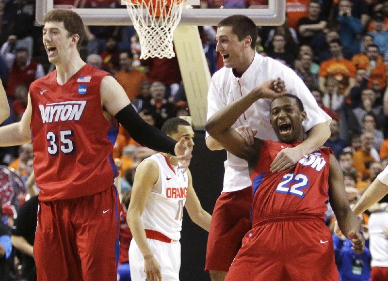 Dayton’s Kendall Pollard (22) and Matt Kavanaugh (35) celebrate after the Flyers defeated Syracuse 55-53 in the NCAA Tournament to advance to the Sweet 16. Syracuse’s Tyler Ennis missed a last-second shot that eliminated the Orange. NCAA Tournament coverage, Pages 4-5C. 