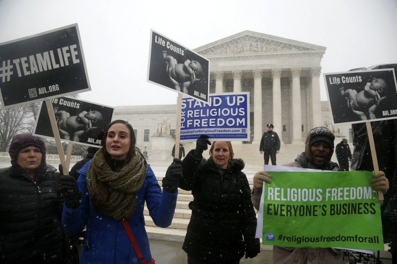 Demonstrators participate in a rally in front of the Supreme Court in Washington on Tuesday, March 25, 2014, as the court heard oral arguments in the challenges of President Barack Obama's health care law requirement that businesses provide their female employees with health insurance that includes access to contraceptives. Supreme Court justices are weighing whether corporations have religious rights that exempt them from part of the new health care law that requires coverage of birth control for employees at no extra charge. 