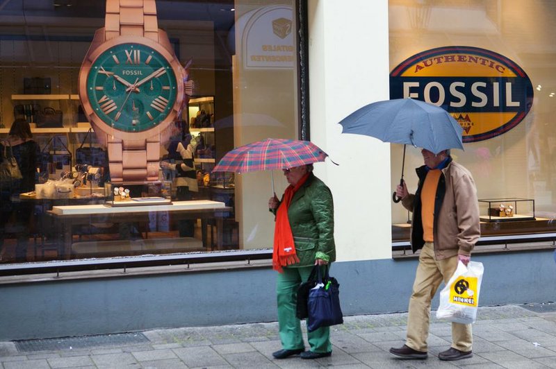 Shoppers pass a the window display of a Fossil wristwatch and apparel store, operated by Fossil Group Inc., in Dusseldorf, Germany, on Saturday, March 22, 2014. Germany is underpinning a euro-region recovery that's under threat from a stronger euro and a slowdown in China. Photographer: Krisztian Bocsi/Bloomberg