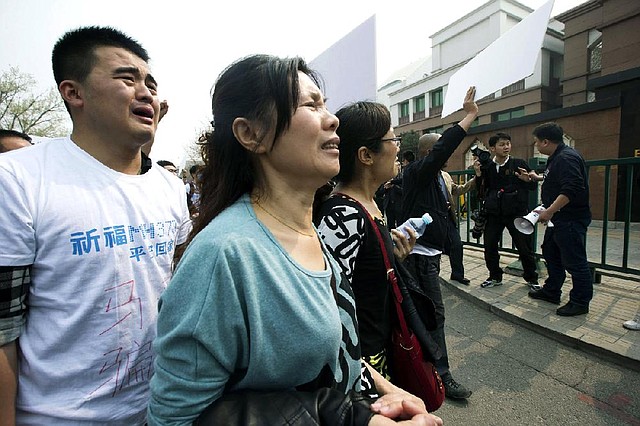 Relatives of Chinese passengers aboard Malaysia Airlines Flight 370 protest outside the Malaysian Embassy in Beijing on Tuesday.
