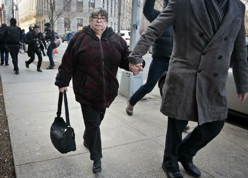 Annette Bongiorno, center, former longtime secretary for imprisoned financier Bernard Madoff, is led from federal court on Monday, March 24, 2014, in New York. Bongiorno is among five former employees of Madoff convicted of fraud that enriched them and cheated investors out of billions of dollars. (AP Photo/Bebeto Matthews)