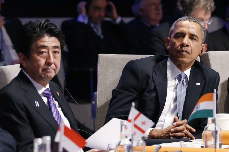 Japan's Prime Minister Shinzo Abe, left, and U.S. President Barack Obama, right, attend the opening session of the Nuclear Summit in The Hague, Netherlands, on Monday, March 24, 2014. Obama gathered with world leaders in a day of delicate diplomacy, as he sought to rally the international community Monday around efforts to isolate Russia following its incursion into Ukraine. Nuclear terrorism was the official topic as Obama and other world leaders streamed in to a convention center in The Hague for a two-day nuclear summit. But the real focus was on a hurriedly scheduled meeting of the Group of Seven industrialized economies to address the crisis in Ukraine on the sidelines of the nuclear summit. (AP Photo/Yves Herman, Pool)