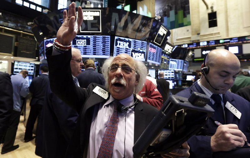 Trader Peter Tuchman (left) works Tuesday on the floor of the New York Stock Exchange. U.S. stocks advanced for the first time in three days as economic data showed consumer confi dence is at a six-year high. 