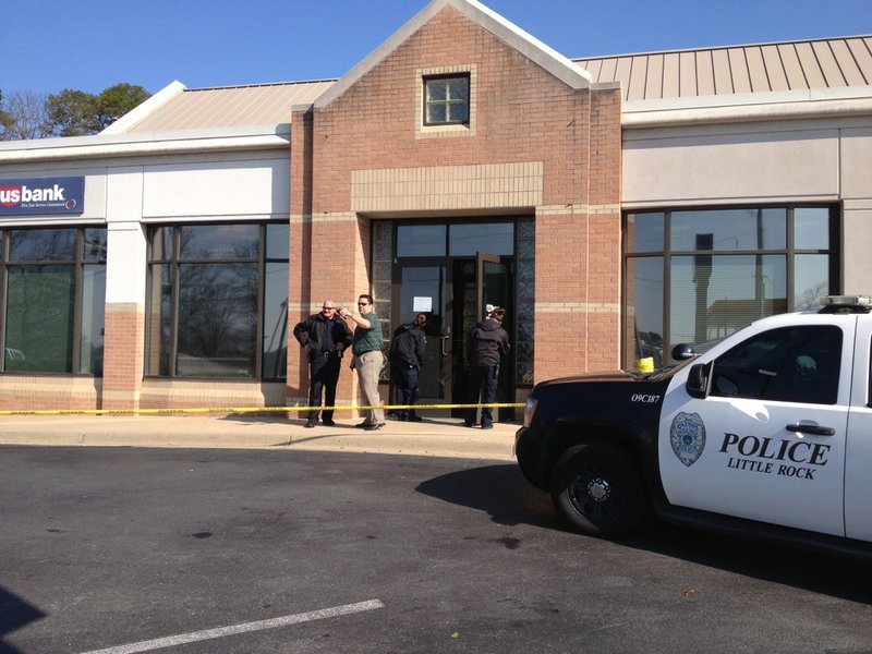 Little Rock police investigate Tuesday, March 25, 2014, after a robbery at the US Bank branch at 6320 W. Markham St.