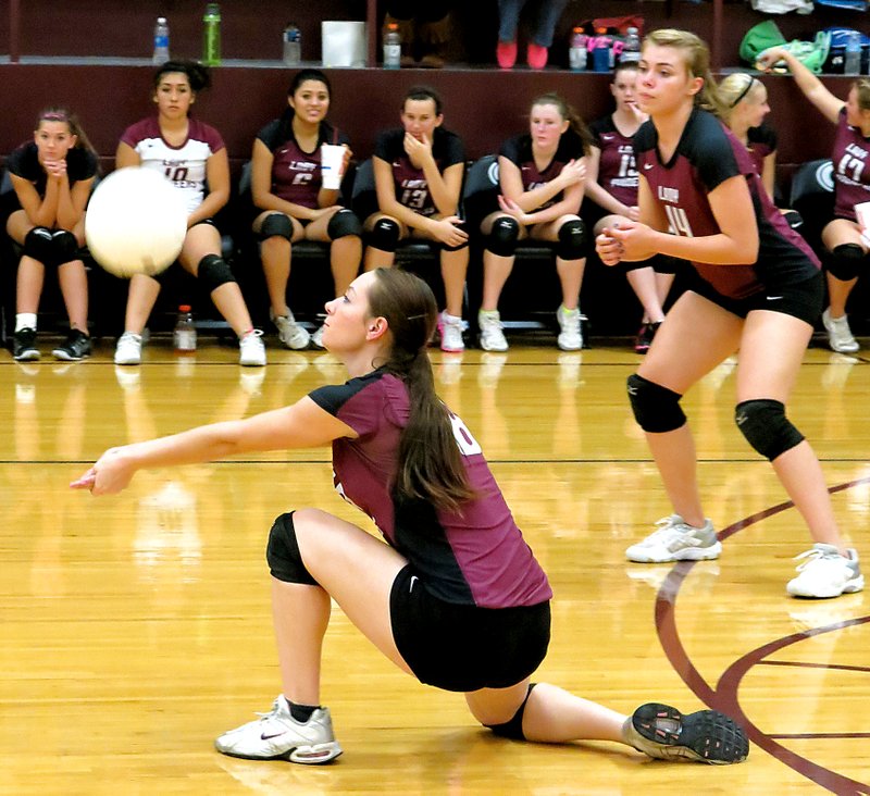 File Photo by Randy Moll Jordan Olds drops to a knee to set up a serve during play in Gentry last fall. Haley Borgeteien-James stands ready behind her.
