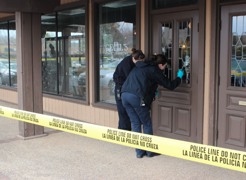 Crime Scene officers dust for prints after an armed robbery of Cecil's Fine Jewelry in Little Rock Thursday.