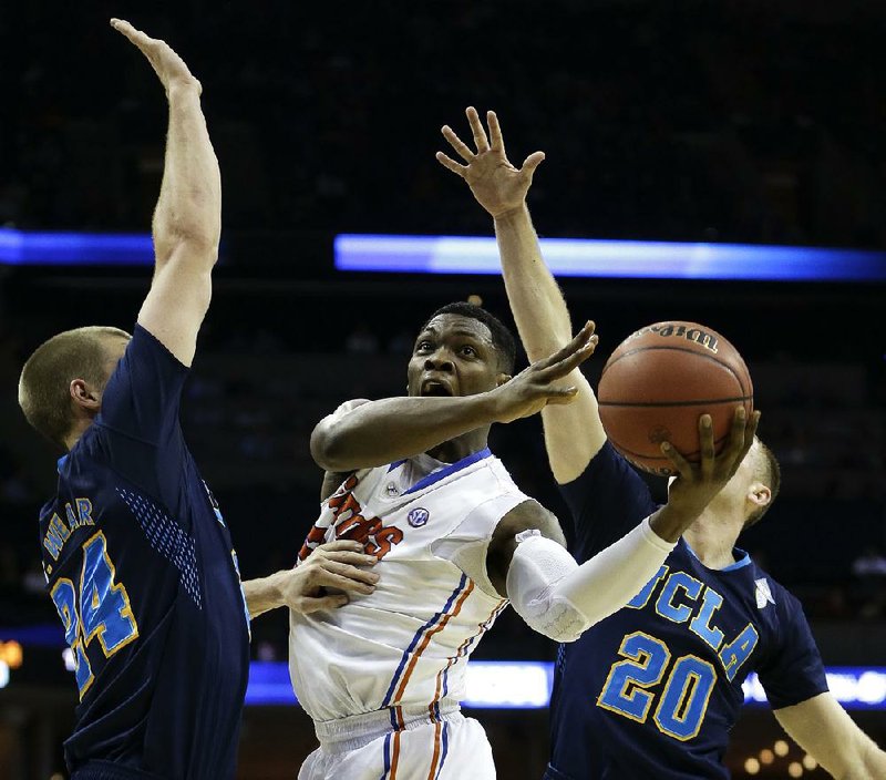 Florida guard Michael Frazier II (20) shoots against UCLA's Travis Wear (24) and Bryce Alford (20) during the first half in a regional semifinal game at the NCAA college basketball tournament, Thursday, March 27, 2014, in Memphis, Tenn. (AP Photo/Mark Humphrey)