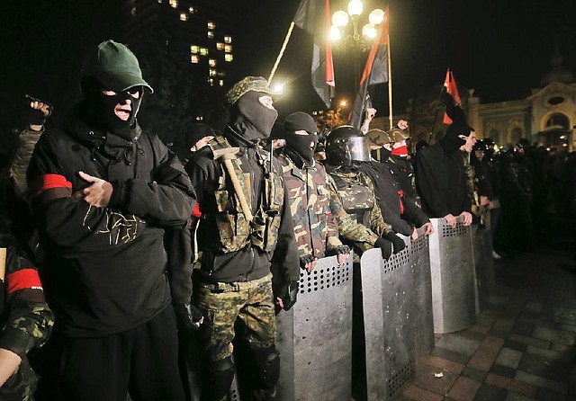 Members of the right wing ultra nationalist Right Sector group block the parliament building in Kiev, Ukraine, Thursday, March 27, 2014. Activists demanded the resignation of the Interior Minister following the recent killing of a Right Sector member Oleksandr Muzychko, who was died during a police operation to detain him. (AP Photo/Efrem Lukatsky)