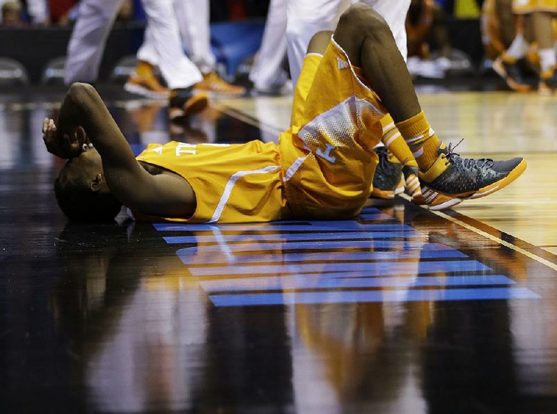Tennessee’s Jordan McRae lays on the court after a last-second shot by the Volunteers was long, giving Michigan a 73-71 victory in a Midwest Regional semifi nal. Tennessee became the first SEC team to lose in this year’s NCAA Tournament. 