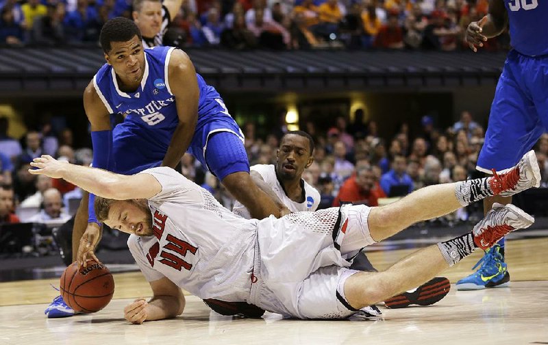 Kentucky’s Andrew Harrison (5) and Louisville’s Stephan Van Treese (44) go for a loose ball during the second half of their Midwest Regional semifinal Friday in Indianapolis. Harrison had 14 points, while his twin brother, Aaron, had 15 to help the eighth-seeded Wildcats win 74-69 and advance to the Elite Eight, where they will face Michigan in Sunday’s regional final. 