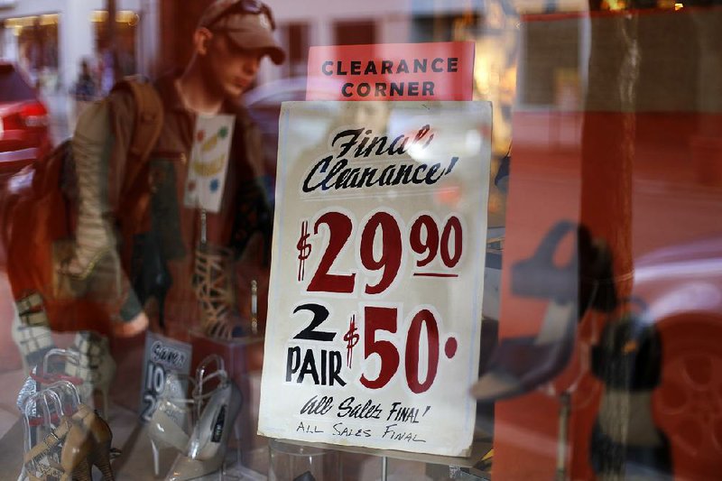 A sale sign hangs Monday in a shoe store window in the Shadyside shopping district of Pittsburgh. Household purchases rose 0.3 percent in February, the Commerce Department said Friday. 