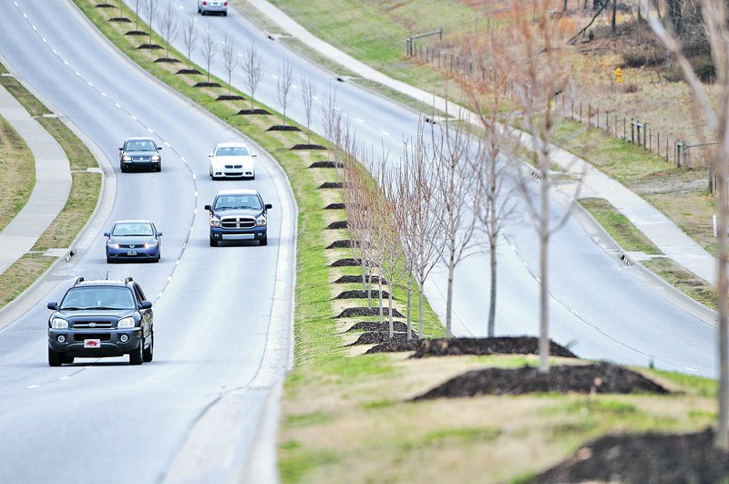 STAFF PHOTO SAMANTHA BAKER &#8226; @NWASAMANTHA Motorists drive Friday along Don Tyson Parkway in Springdale. Cities across Northwest Arkansas have been including landscaping as a part of road improvement.
