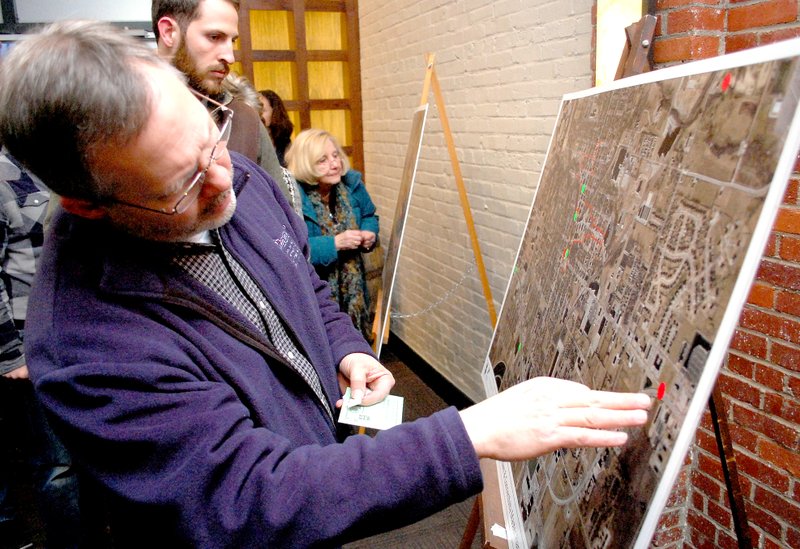 File photo People interested in the downtown master plan look at city maps in a public meeting held Feb. 11. The planning company hired to develop the plan will host two public meetings this week and set up a design studio to receive public comments.