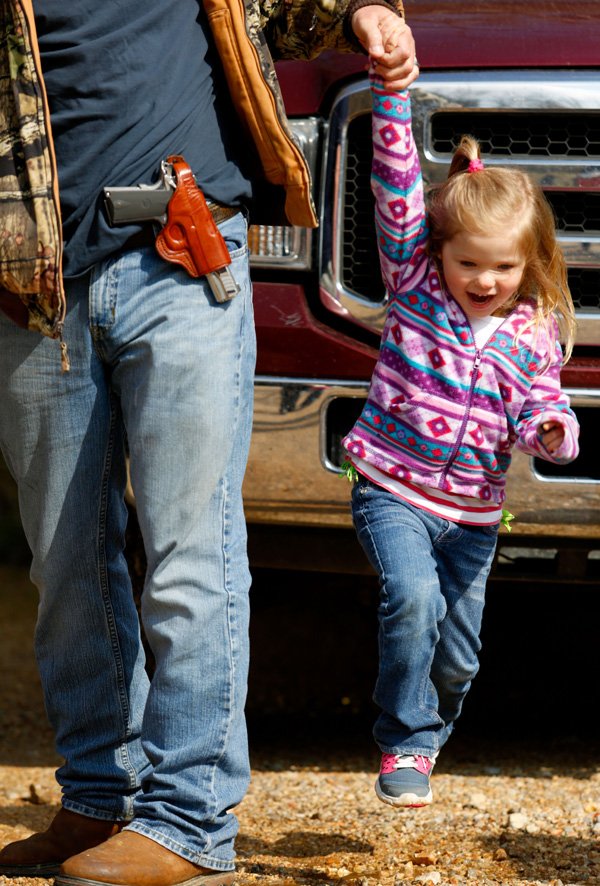 NWA Media/JASON IVESTER --03-29-2014--
Jimmy Maxwell playfully lifts his daughter Faith Maxwell, 3, both of Romance, as they wait on Saturday, March 29, 2014, to march with the Northwest 746, a group that supports open carry of firearms, along Arkansas 23 into Eureka Springs.