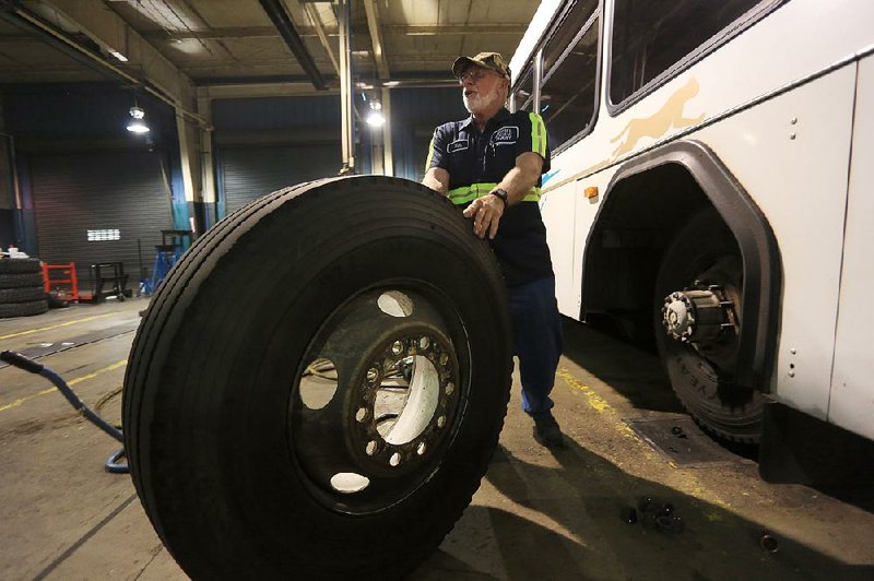 Arkansas Democrat-Gazette/RICK MCFARLAND --03/28/14--   Jim Mark, with Central Arkansas Transit Authority, removes a tire, weighing 250 lbs, from one of their buses in the CATA garage in Little Rock Thursday.