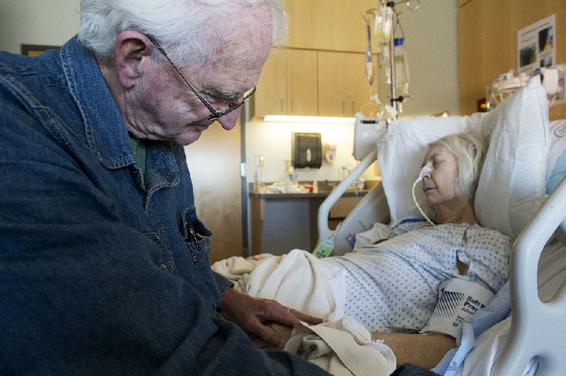 Arkansas Democrat-Gazette/MELISSA SUE GERRITS - 03/20/2014 - Fred Oliver rubs his wife, Doris' hand while she rests in a UAMS hospital room March 20, 2014. Fred has been able to stay overnight in the single patient room with his wife thanks to UAMS's new patient programs which aim at a pleasant an personal experience for each patient. 