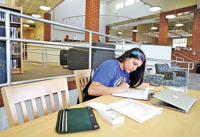 STAFF PHOTO DAVID GOTTSCHALK Cynthia Ortiz, 15, studies food science from her Lincoln High School class Thursday at the Lincoln Public Library.