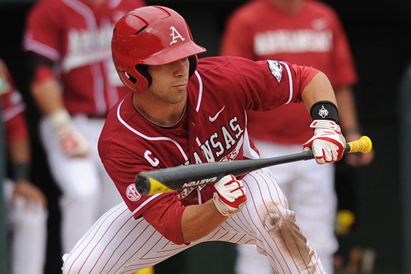 Arkansas' Tyler Spoon lays down a bunt to move Brian Anderson into scoring position during the eighth inning of play against Alabama Saturday, March 22, 2014, at Baum Stadium in Fayetteville.