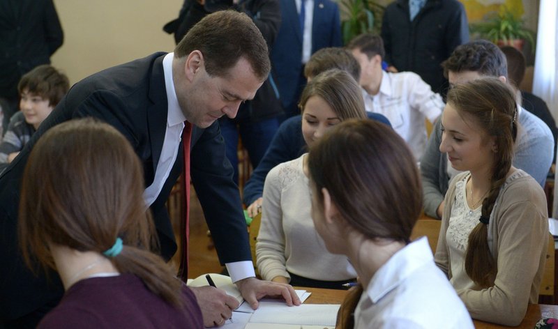 Russian Prime Minister Dmitry Medvedev, second left, speaks to schoolchildren while visiting Crimea in Simferopol, Crimea, on Monday, March 31, 2014. Russia's prime minister is visiting Crimea to consider priorities for its economic development after the Russian takeover. 
